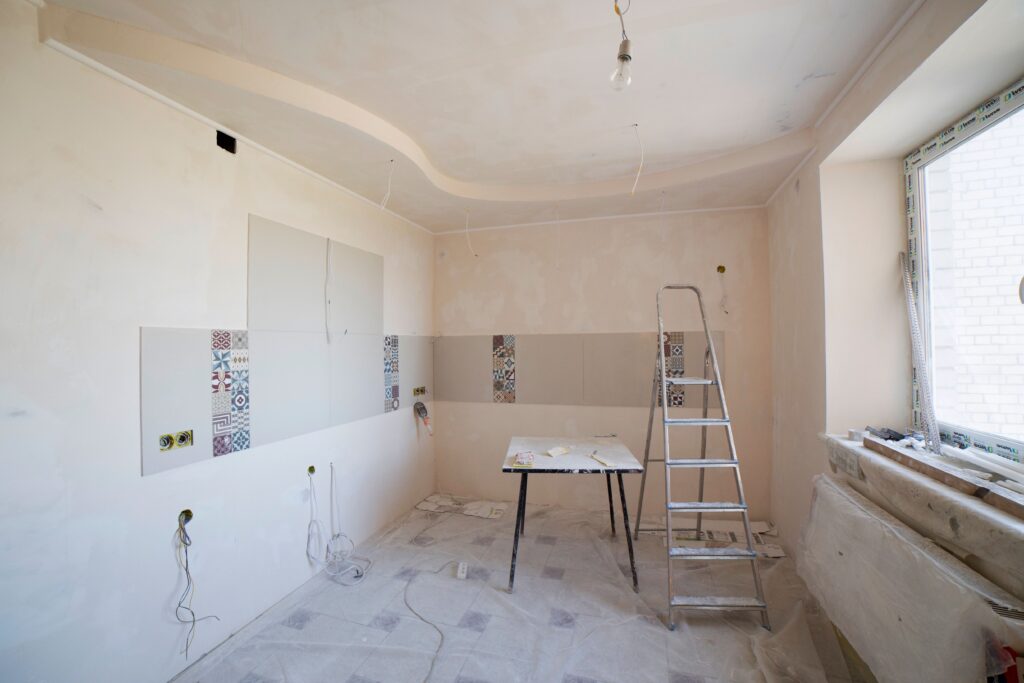 service-1 Spacious kitchen under renovation with ladder and tools, showcasing a fresh new design.
